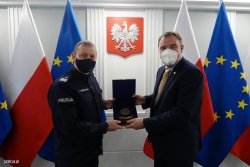 Deputy Commander-in-Chief of the Police and Director of Cybercrime at Interpol posing to photo with a commemorative board